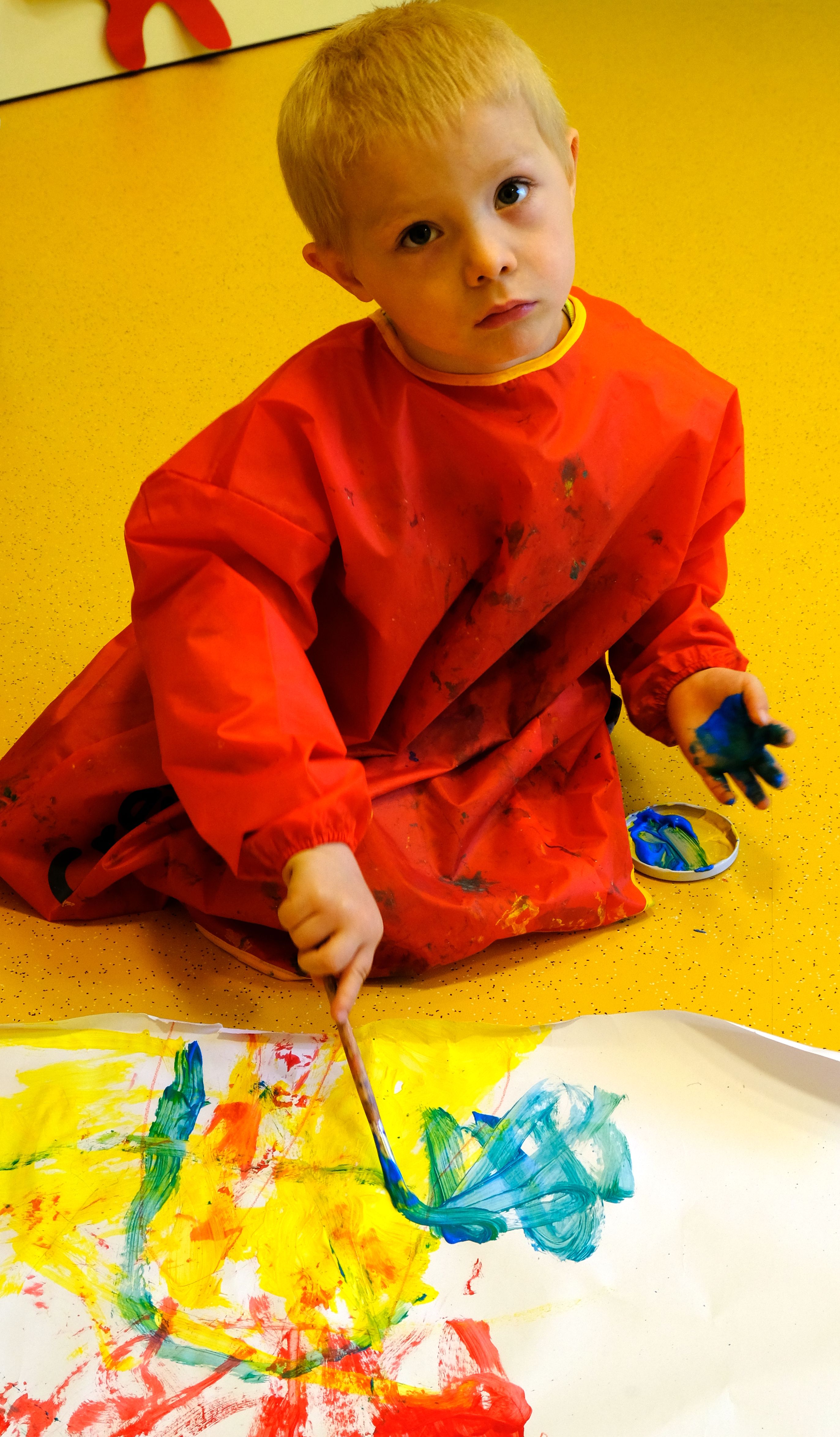Foto: Ein Junge beim Malen mit bunten Farben