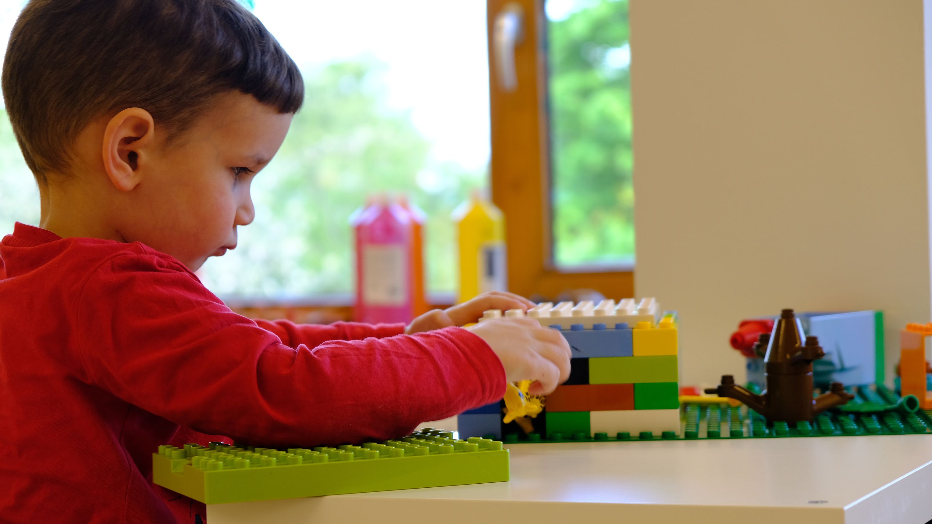 Foto: Ein Junge baut mit Lego-Steinen