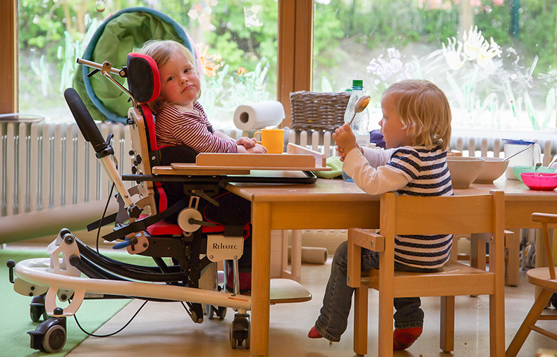 Foto: Ein Mädchen im Rollstuhl beim Frühstück